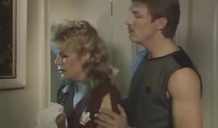 Trẻ, tóc vàng, với một xem phim sec ba gia lớn trong quần đùi nghỉ ngơi trên giường